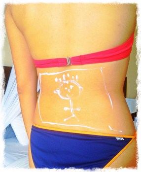 girl-bikini-on-back-happy-face-made-of suntan-lotion