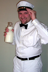 milkman-dressed-in-white-with-glass-bottle-of-milk