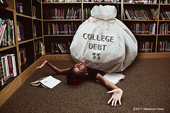 college-debt-for-student-with-big-bag-of-iou-holding-her-down