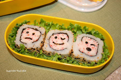 sushi-smiling-faces-cross-section-served-on-plate-ca-roll