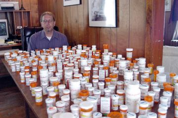 ne-man-overlooking-landscape-pain-medication-bottles-ouch