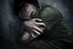 man-cowering-hiding-his face-by-holding his-arms-protecting-his neck