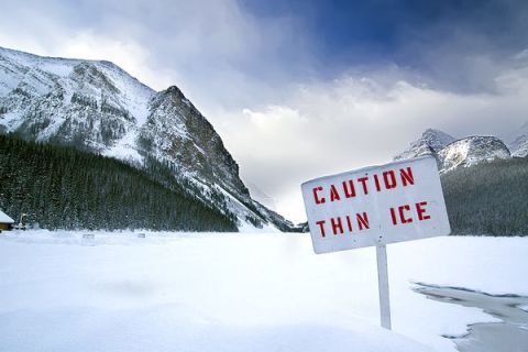 caution-thin-ice-sign-on-lake-within-mountains